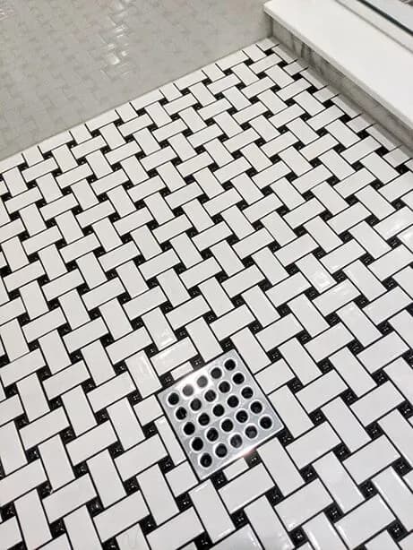 A black and white mosaic style tiled Epoxy Sealed Shower Pan.