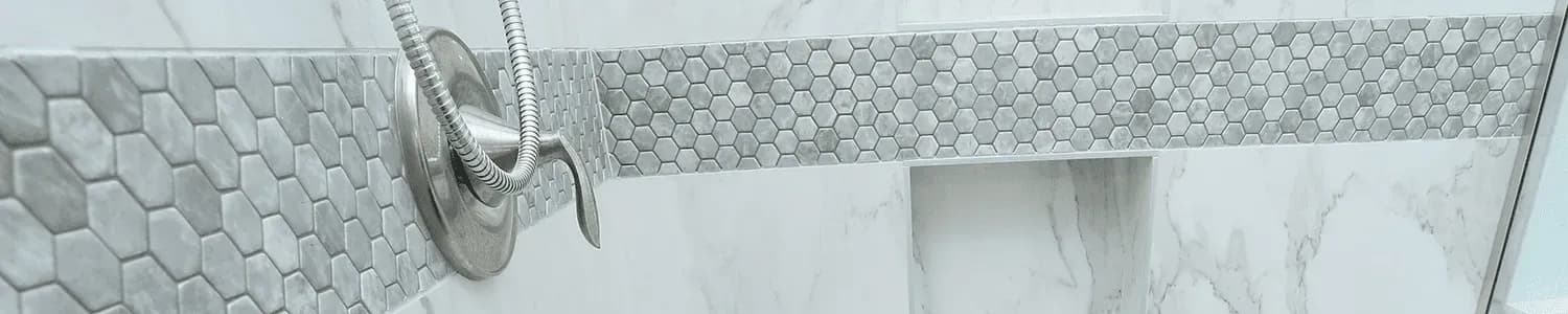 Detail close-up of a hexagonal gray tile in a walk-in shower.